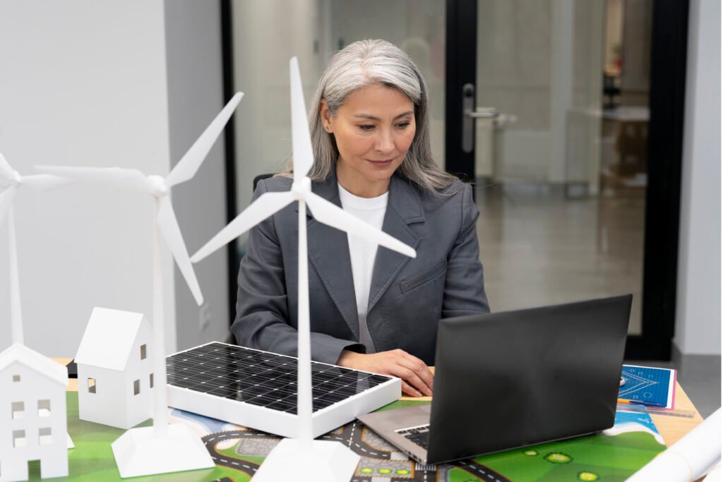 A professional woman with gray hair working on a laptop in an office