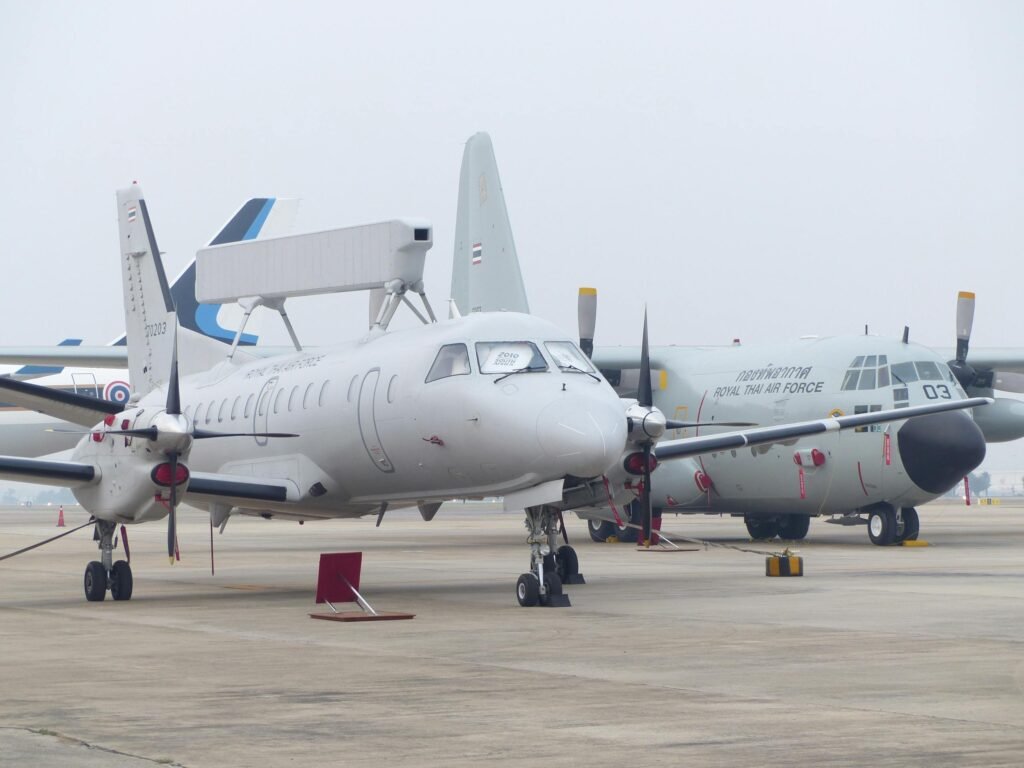 A military aircraft parked on the runway at an airport, highlighting the aviation theme.